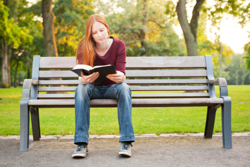 woman reading on bench